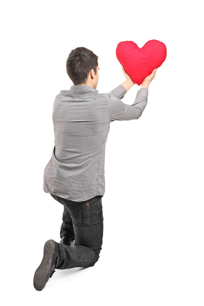Young man holding a red heart - Foto, Bild