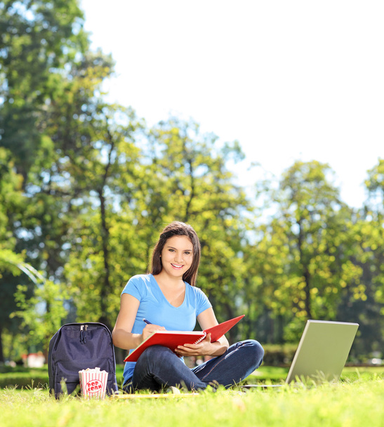 Girl writing in notebook outdoors - Foto, imagen