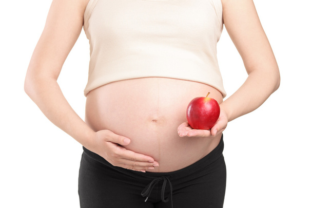 Pregnant woman holding a red apple - Zdjęcie, obraz