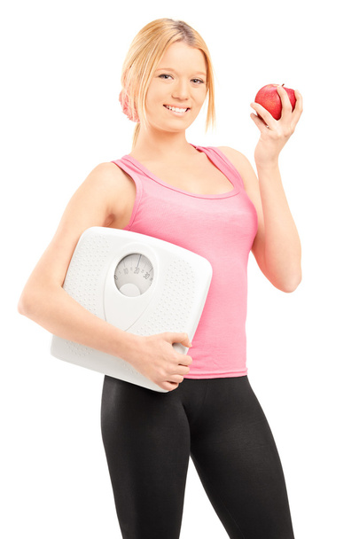 Female holding weight scale and apple - Фото, изображение