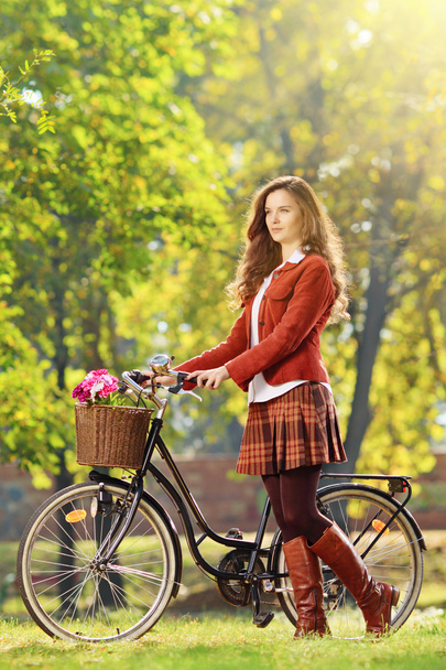 Young female with bicycle relaxing in a park - Photo, Image