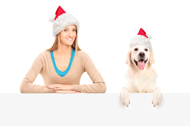 Female and dog wearing santa claus hats - Fotoğraf, Görsel