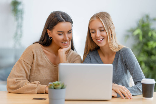Two happy young women doing online purchases. Girls doing shopping at home. - Foto, immagini