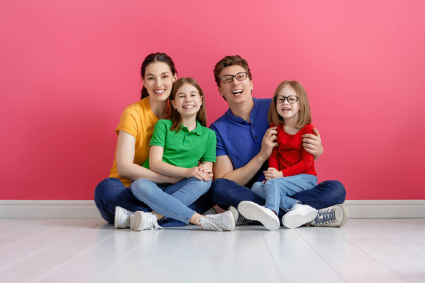 Happy loving family. Mother, father and children daughters on pink background. - Valokuva, kuva