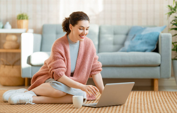 Happy casual beautiful woman working on a laptop at home. - Foto, Bild