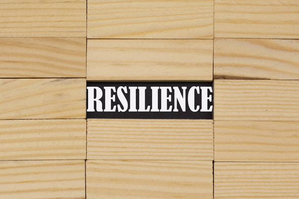La palabra resiliencia entre las barras de madera. - Foto, imagen