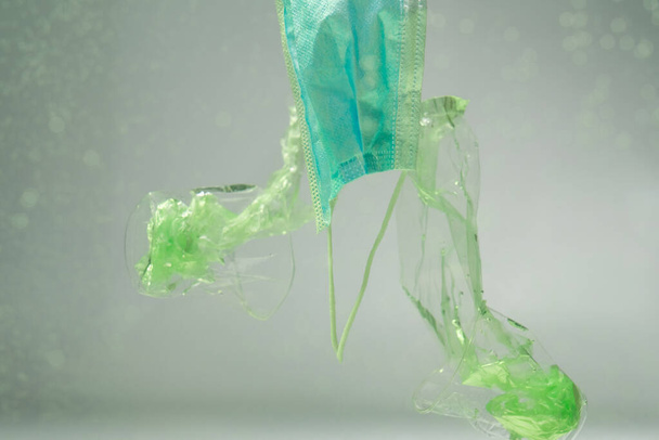 plastikowe opakowania i kubki w pobliżu maski medycznej pod wodą, ekologia koncepcja - Zdjęcie, obraz