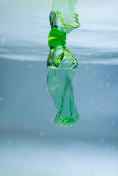 crumpled plastic bottle in water, ecology concept - Photo, Image