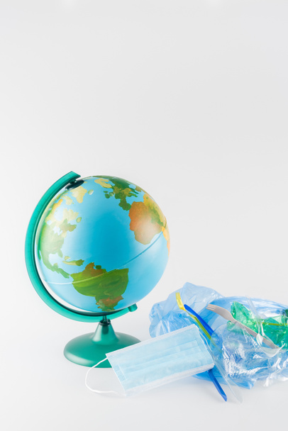 globe near cellophane bag with plastic rubbish on grey, ecology concept - Photo, Image