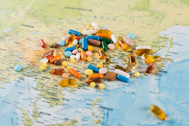 pile of pills on map, blurred background, ecology concept - Photo, Image
