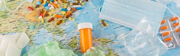 top view of pills, medical mask and plastic garbage on map, ecology concept, banner - Photo, Image