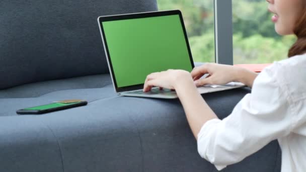 Ev bilgisayarında çalışan bir kadın merkez ofiste online toplantı yapıyor. Dizüstü bilgisayar kullanan girişimci Asyalı iş kadını kanepe teknolojisinde yeni normal yaşam tarzında oturuyor. Klavye dizüstü bilgisayarı yazan mutlu kadın - Video, Çekim