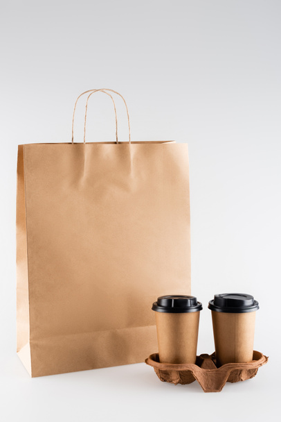 бумажный пакет и одноразовые чашки на сером, экологическая концепция - Фото, изображение