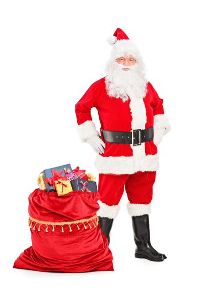 Санта-Клаус рядом с сумкой, полной подарков
 - Фото, изображение