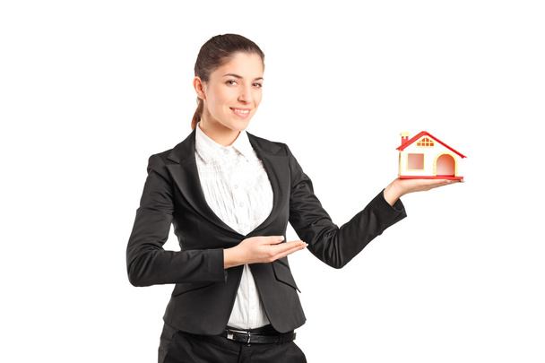 Businesswoman holding a small toy house  - Zdjęcie, obraz