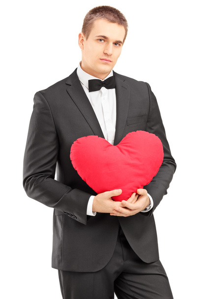 Handsome man holding a red heart - Foto, Imagen