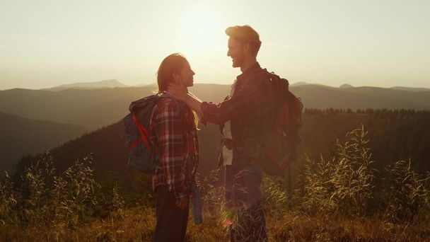 Любимые девушка и парень проводят время вместе в горах на закате - Фото, изображение