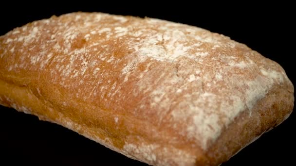 Ciabat brood op een zwarte achtergrond close-up. - Video