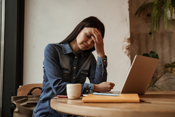 freelance stanco che soffre di mal di testa vicino a computer portatile su tavolo - Foto, immagini
