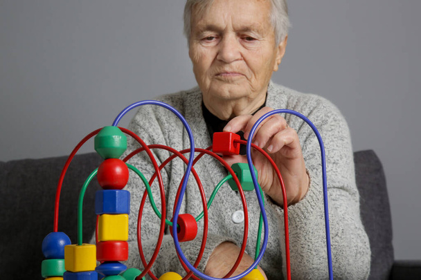 Starsza kobieta zapobiegania chorobie Alzheimera i demencji spowalnia jej postęp poprzez wspieranie uczenia się i pamięci poprzez grę. - Zdjęcie, obraz