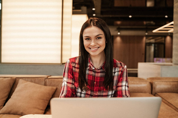 donna gioiosa sorridente vicino a computer portatile in caffè - Foto, immagini