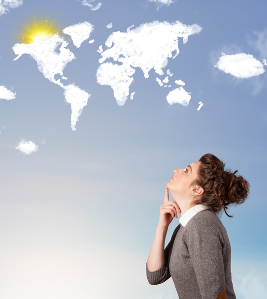 Young girl looking at world clouds and sun on blue sky - 写真・画像