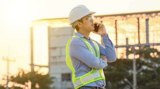 Mérnöki beszélgetés mobiltelefonon az építkezésen  - Fotó, kép