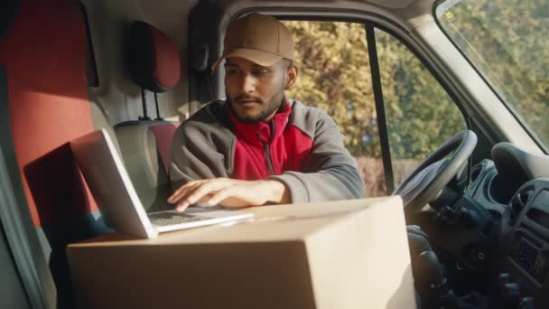 Mensajero usando el portátil en la furgoneta para confirmar la dirección de entrega - Metraje, vídeo