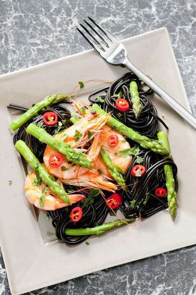 Esparguete sépia com camarão, espargos e pimenta
 - Foto, Imagem