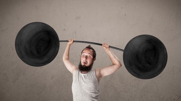 Funny skinny guy lifting weights - Valokuva, kuva