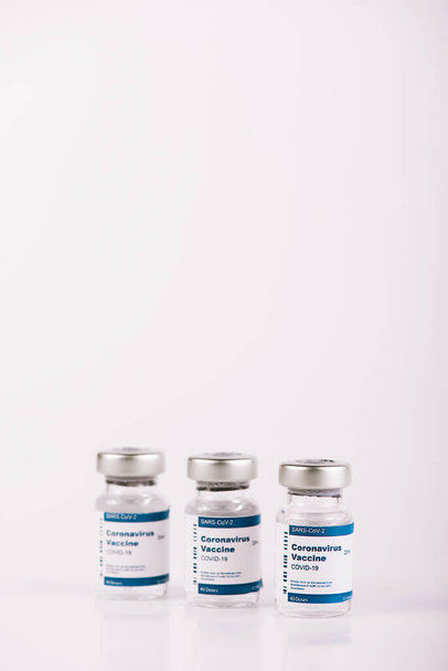kolme Covid-19-rokoteinjektiopulloa, joissa on valkoista taustaa hoitohenkilökunnan ja riskiryhmien injisoimiseksi. SARS-CoV-2-rokotehoito. Kopioi tila. - Valokuva, kuva