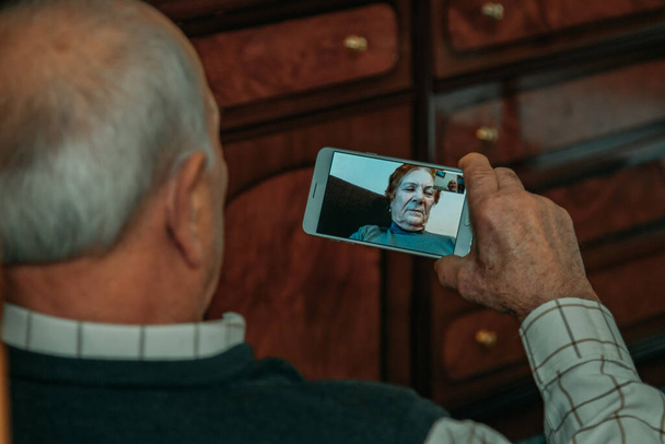 祖父や先輩が携帯電話でビデオ通話をしたり - 写真・画像
