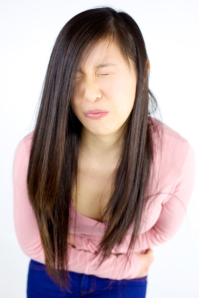 Young asian girl with strong stomach ache - Фото, изображение