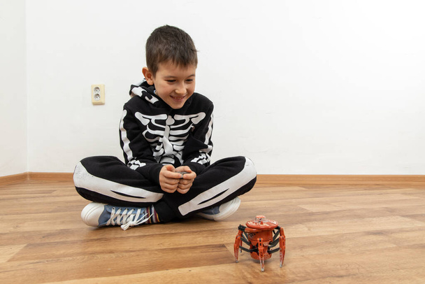 Fiú játszik pók robot játék a földön otthon - Fotó, kép