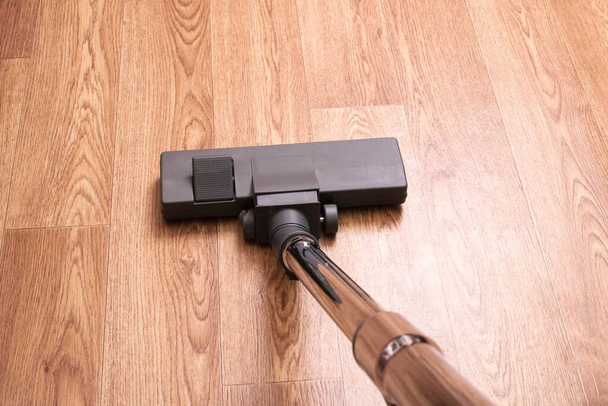 Cepillo de aspiradora en un piso de madera de cerca - Foto, Imagen