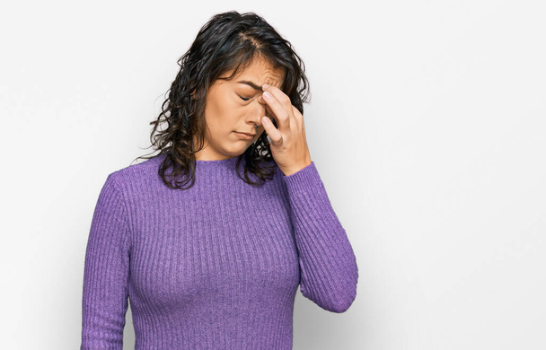 Young hispanic woman wearing casual clothes tired rubbing nose and eyes feeling fatigue and headache. stress and frustration concept.  - Photo, Image