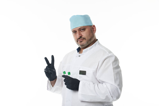 Αυτοπεποίθησή πορτρέτο του όμορφος γιατρός με ιατρική στολή, κοιτάζοντας κάμερα στέκεται απομονωμένη σε λευκό φόντο με αντίγραφο χώρο - Φωτογραφία, εικόνα