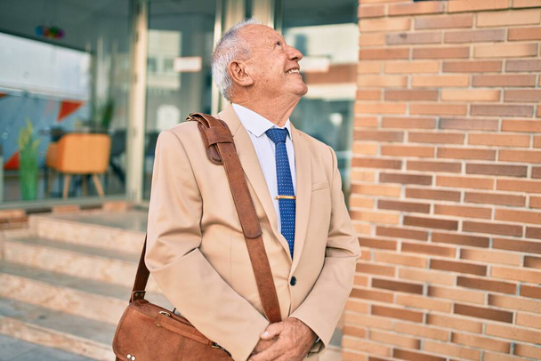 Senior grey-haired businessman smiling happy standing at the city. - Foto, immagini