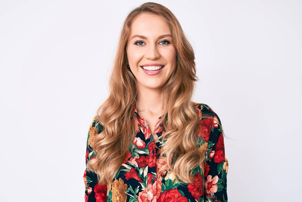 Young caucasian woman with blond hair wearing elegant floral shirt with a happy and cool smile on face. lucky person.  - Foto, afbeelding