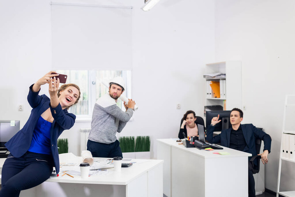Quatre personnes prenant un selfie drôle dans le bureau - Photo, image