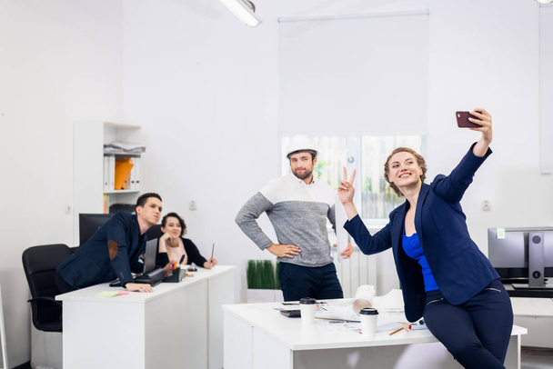 I dipendenti si divertono in ufficio, posando e scattando selfie con - Foto, immagini