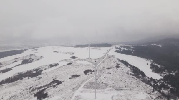 Widok z powietrza na farmę wiatrową w zimie, Turbiny obrotowe na zaśnieżonym polu na Ukrainie - Materiał filmowy, wideo