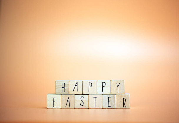 Happy Easter written with pastel colored orange background and bright spring flowers, greeting card,spring,colors,Easter Holiday concept copy space - Φωτογραφία, εικόνα