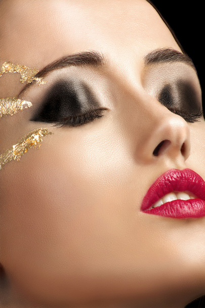 Close-up shot of female face with  golden shining eye makeup - Fotografie, Obrázek