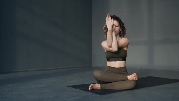 Jonge aantrekkelijke dame ontspannen zitten in yoga asana - Video