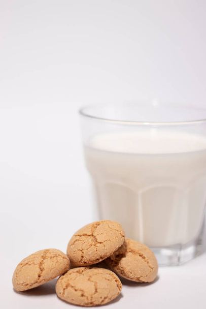 glass of milk near almond amaretti cookies isolated on white background. healthy breakfast snack. - Photo, Image