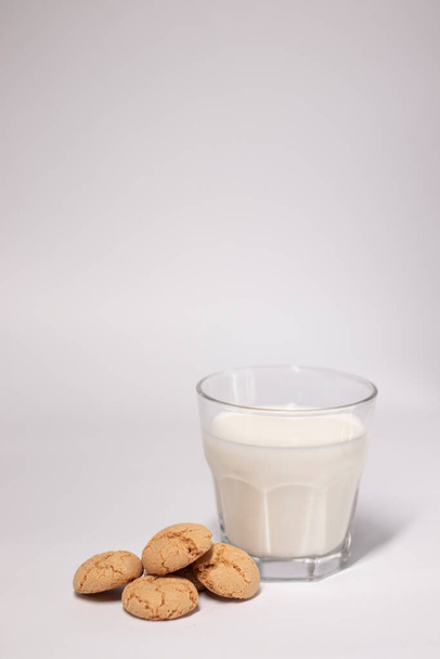 glass of milk near almond amaretti cookies isolated on white background. healthy breakfast snack. - Photo, Image