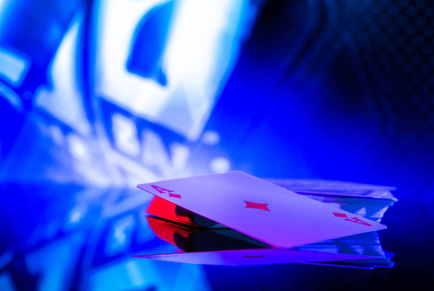 Poker hrací karty na skleněném stole s modrým osvětlením. Motiv hazardních her v kasinu. - Fotografie, Obrázek