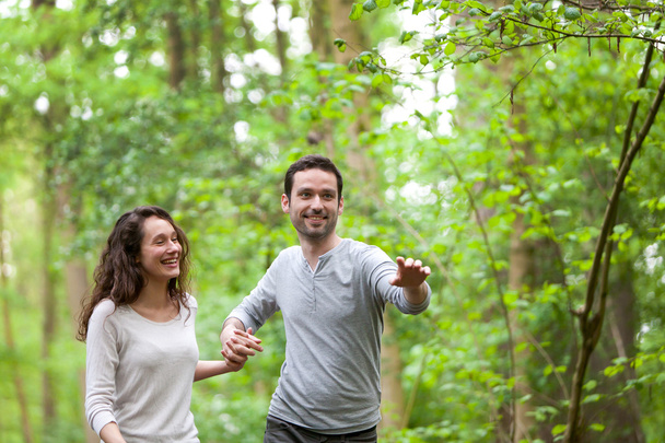 Young couple having a walk in a forest - Foto, imagen