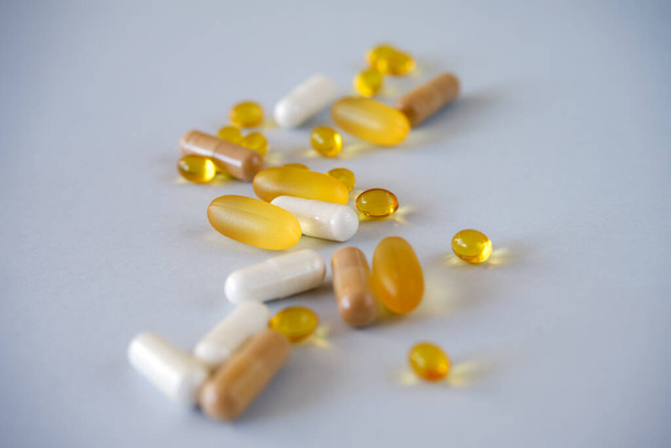 Gel amarillo cápsulas nutracéuticas de gel transparente de vitamina d o omega 3 en cuchara. - Foto, Imagen